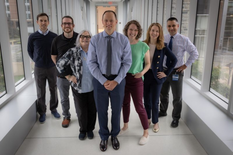 Seven members of the Virginia Tech Carilion School of Medicine Stemmler Fund team stand together on a bridge.